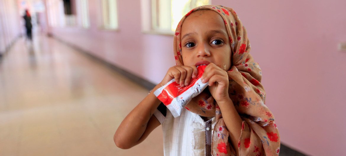 یک دختر کوچک در حالی که به دلیل سوءتغذیه در یک آسایشگاه در صعنا، یمن تحت درمان قرار می گیرد، یک خمیر بادام زمینی می خورد.