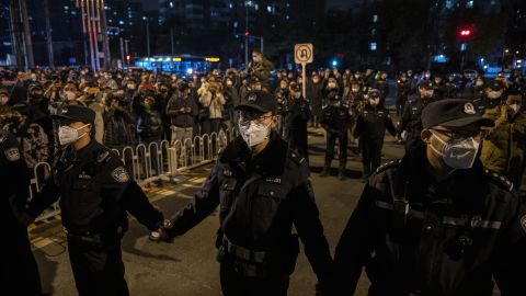 پلیس در جریان تظاهرات در پکن در 27 نوامبر 2022 یک حلقه تشکیل داد.