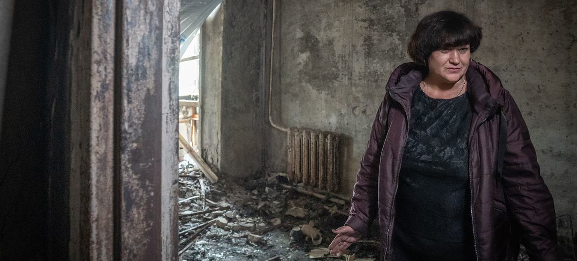 یک زن پس از اصابت موشک به مجتمع مسکونی او در Zaporizka اوکراین در خانه آسیب دیده خود ایستاده است.